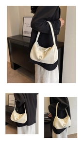 Vue détaillée du sac sous le bras en forme de croissant blanc avec boucle C en perle nacrée
