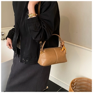 Détail d'un sac à main marron en cuir avec une élégante chaîne dorée sur la bandoulière
