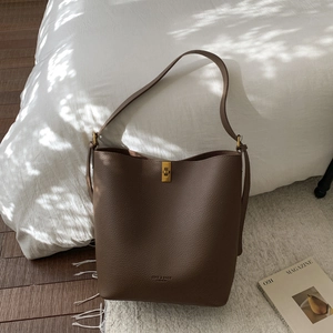 Gros plan détaillé d'un sac seau en cuir grainé marron foncé avec boucle dorée