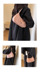 Détail du sac sous le bras en similicuir rose avec texture marbrée et logo en métal C