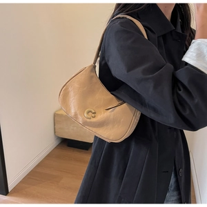 Détail d'un sac porté épaule en PU beige avec boucle logo C dorée au style vintage