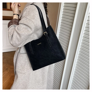 Detail view of black vintage tote bag with gold JIANXIANG logo and adjustable strap