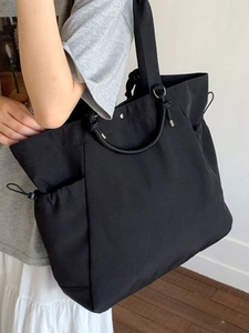 Minimalist black large capacity tote bag with drawstring side pockets for daily travel