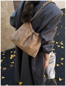 Detail of vintage brown suede bucket bag with star embroidery and silver chain strap