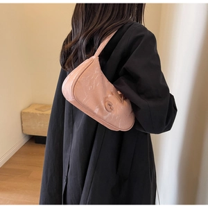 Détail du sac en cuir rose avec texture marbrée et logo C en relief sur le devant