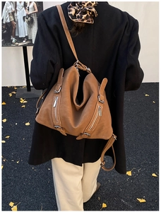 Brown vintage tote bag featuring adjustable shoulder straps and stylish metal zipper details