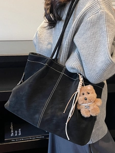Minimalist large black tote bag with white contrast stitching and plush bear charm