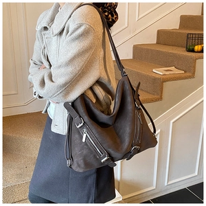 Detailed close-up of dark brown vintage tote bag featuring silver zipper and buckle accents