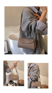 Detail of khaki pebbled leather crossbody bag with elegant round gold metal clasp closure