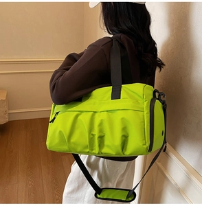 Detail of neon green fitness bag with side zipper compartment and shoulder strap