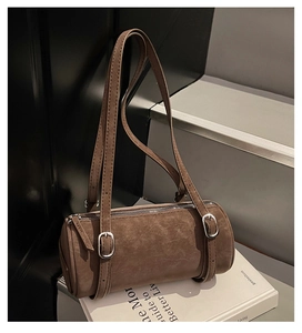 Macro detail of brown retro cylinder shoulder bag with adjustable straps and silver zippers
