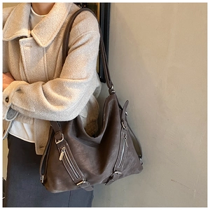 Detail view of vintage dark brown tote with silver side zippers and metallic buckles
