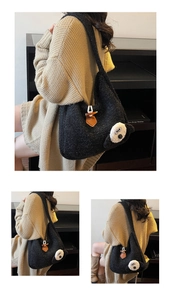 Close-up of black plush tote bag featuring a cute panda design and brown leather toggle