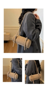Detailed close-up showing adjustable silver buckles on a cylinder shoulder bag