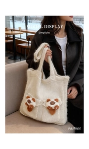 Detail shot of a cream-white knit tote bag featuring cute 3D plush cat charms and two pockets