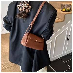 Brown litchi grain leather crossbody bag styled on a model with a black oversized blazer