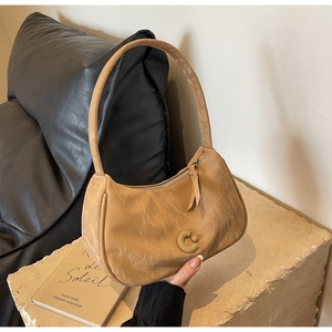 Détail du sac hobo kaki avec texture marbrée et logo en forme de C en relief