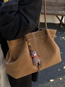Minimalist dark brown suede tote bag with contrast stitching and bear charm for women