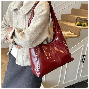 Detailansicht der weinroten Lackleder-Achseltasche mit silbernen Nieten-Details