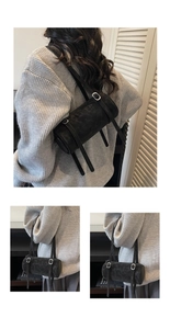 Detail of a black cylinder shoulder bag in matte suede texture with double straps
