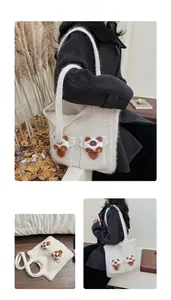 Close-up of cream knit tote bag with plush bear charms and thick shoulder strap