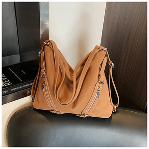 Detail view of the caramel brown vintage tote bag with metal zippers and soft leather texture