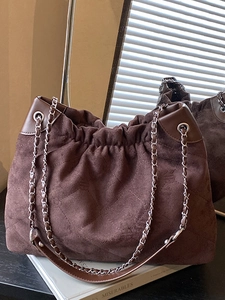 Quilted dark brown suede hobo bag with silver chain strap and drawstring closure