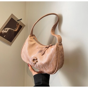 Détail du sac à bandoulière en similicuir pêche avec texture marbrée et décor en C