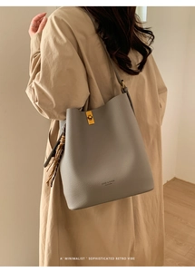 Détail du sac seau gris en cuir grainé avec foulard en soie et fermoir doré