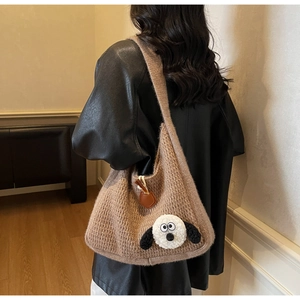 Close-up of brown knit hobo bag featuring a 3D plush cartoon animal decoration on shoulder