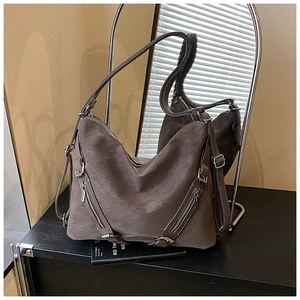 Detail view of a vintage dark grey-brown suede tote bag with decorative metal zippers