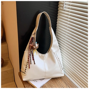 Detailansicht der weißen PU-Leder Hobo-Tasche mit Nieten und braunem Bärenanhänger