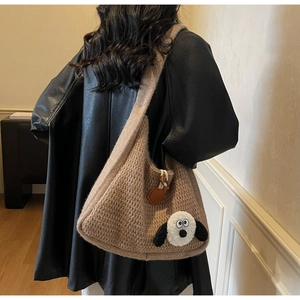 Macro detail of brown chunky knit shoulder bag featuring a cute plush cartoon charm