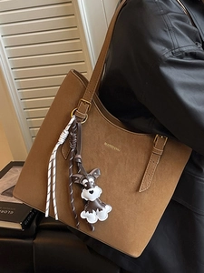 Brown suede tote bag with shoulder strap and a cute dog charm for casual work use