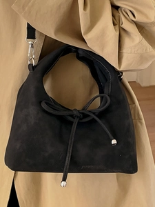 Minimalist black suede hobo shoulder bag with a delicate leather bow and silver metal beads