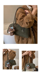 Detail of dark green matte shoulder bag with white stitching and cute bear charm
