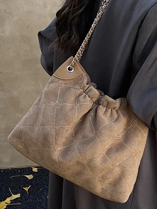 Brown quilted bucket bag with chain strap and soft matte finish for casual wear