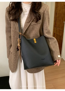 Vue détaillée du sac à main noir en cuir grainé avec fermoir doré et foulard en soie