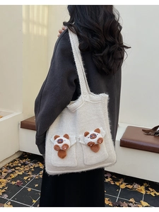 Chic knit tote bag with 3D plush cat charms shown in a casual outdoor autumn setting