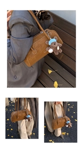 Detail showing the retro caramel brown suede texture and cute teddy bear bag charm