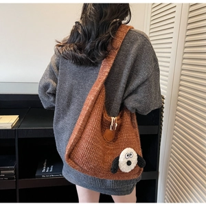 Detailed knit texture and cartoon character patch on a large caramel knitted tote bag