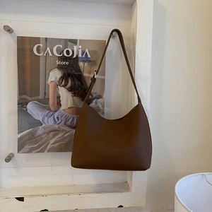 Close-up of the vintage brown semi-circle bucket bag with elegant lychee pattern leather
