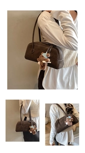 Detail of dark brown suede shoulder bag with a cute bear charm and zip closure