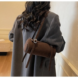 Detailed side view of vintage brown cylindrical bag featuring premium matte suede texture