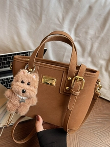 Retro brown crossbody handbag with plush puppy charm and metallic buckle details