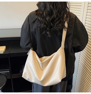 Close-up of a large cream-colored slouchy hobo bag with soft leather pleats and texture