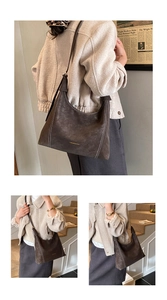 Detailed view of deep brown vintage leather tote with white stitching and fashion logo