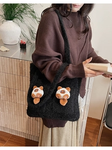 Detail of cute 3D cartoon cat plush dolls on a black fuzzy oversized shoulder tote bag