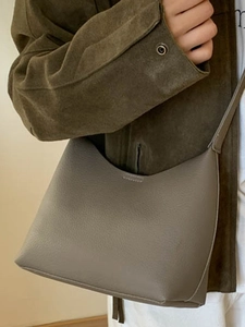 Chic taupe pebbled leather hobo bucket bag styled on a model for a trendy winter look