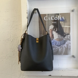 Détails du sac seau en cuir noir grainé avec fermoir en métal et pendentif ours